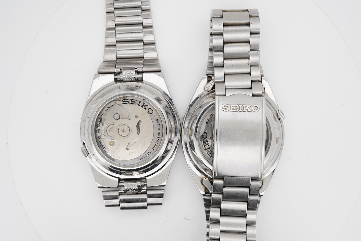 Two gentleman's recent stainless steel Seiko 5 automatic day/date wrist watches, one with black dial, the other blue dial, case diameters 36mm, both on stainless steel Seiko straps (one a.f.). no boxes or paperwork.
